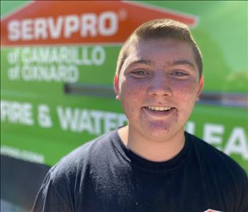 Portrait of Nick, male employee in front of green truck