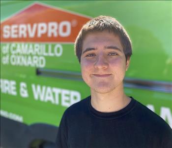 Portrait of Louden, male employee in front of green truck