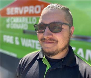 Portrait of Andres, male employee in front of green truck